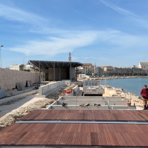 PROCEDONO LE LAVORAZIONI PER LA RIQUALIFICAZIONE DEL MOLO SANT’ANTONIO: COMPLETATA LA STRUTTURA DEL MUSEO DEL MARE, PRENDE FORMA LA “PASSEGGIATA SUL MARE” CON LE PEDANE IN LEGNO